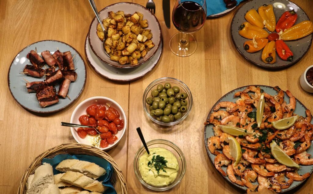 A selection of Spanish tapas with wine on a wooden table in Seville